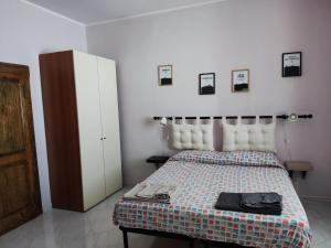 1 dormitorio con 1 cama, armario y cuadros en la pared en Come a Casa - Like home en Tocco da Casauria