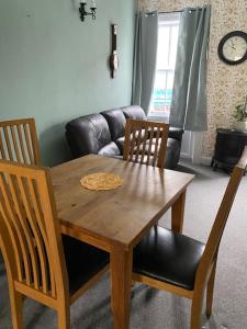 a wooden table and chairs in a living room at The flat at the crooked house in Ulverston