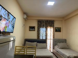 a living room with a couch and a flat screen tv at Hotel Asteri in Velipojë
