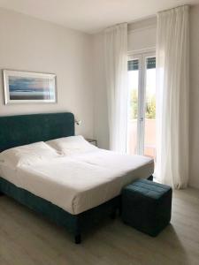 a bedroom with a large bed and a large window at Hotel Bencista' in Marina di Pietrasanta