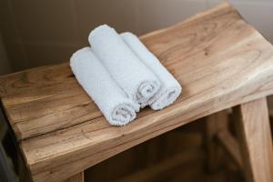 two rolled towels sitting on a wooden table at Séjour14 -- Gastenverblijf - volledige 1e verdiep in Veurne