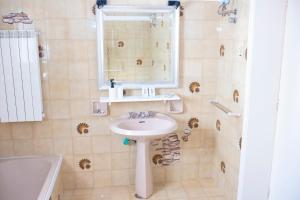uma casa de banho com um lavatório, um espelho e uma banheira em Casa vacanza “La Maison de famille” em Surbo
