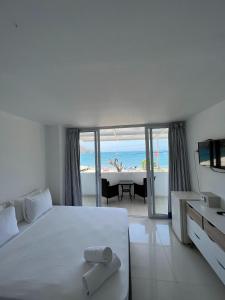 a bedroom with a white bed with a view of the beach at La Ballena Azul Hotel in Taganga