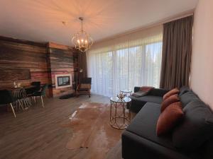un soggiorno con divano e tavolo di Luxury Silver Mountain Apartment a Poiana Brasov