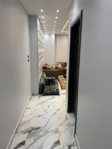 a hallway with marble flooring and a living room at شقه فندقيه الترا لوكس in Asyut