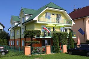 a yellow house with a balcony with an umbrella at Willa Elżbieta in Rewal