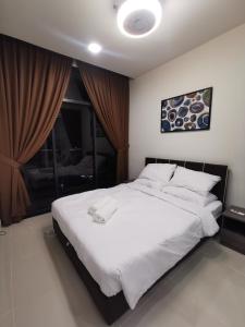 a bedroom with a large white bed with a window at THE SHORE KOTA KINABALU - SABAKUBA HOMESTAY (B2010) in Kota Kinabalu