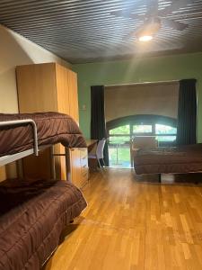 a room with two bunk beds and a wooden floor at Albergue & Cafetería Vía de la Plata Hervás in Hervás