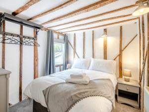 a bedroom with a bed with white sheets at Meadowland in Thornham Magna