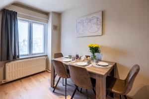 een eetkamer met een tafel en stoelen en een raam bij Séjour14 -- Gastenverblijf - volledige 1e verdiep in Veurne