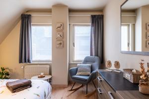 een slaapkamer met een bed, een stoel en een bureau bij Séjour14 -- Gastenverblijf - volledige 1e verdiep in Veurne