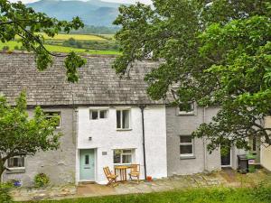 a cottage with a table and chairs in front of it at Osprey Cottage in Bassenthwaite