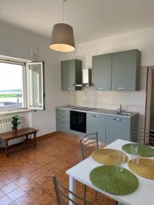 a kitchen with a table and chairs and a kitchen with a window at Casa Lea - Sperlonga in Sperlonga