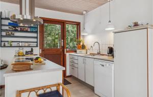 eine Küche mit weißen Schränken und einem weißen Kühlschrank in der Unterkunft 3 Bedroom Beautiful Home In Nexø in Neksø