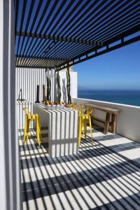 a deck with a table and chairs and the ocean at Villa Augustine in Tangier