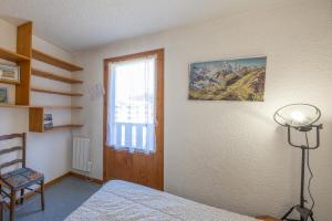Appartement Prarion Mont Blanc في لي أوش: غرفة نوم بسرير ونافذة