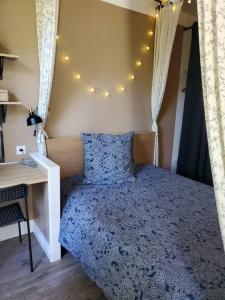 Schlafzimmer mit einem Bett, einem Schreibtisch und Lampen in der Unterkunft La Grelauderie 2 in Saintes