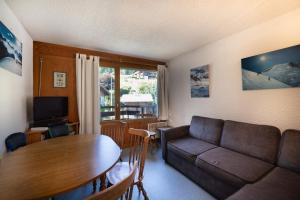 Appartement Prarion Mont Blanc في لي أوش: غرفة معيشة مع أريكة وطاولة