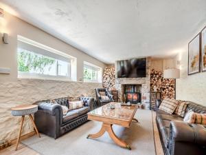 a living room with leather furniture and a fireplace at The Cottage At West Brinsea Farm in Churchill