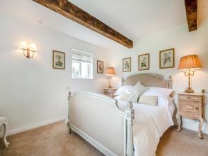 a bedroom with a bed and two lamps at The Cottage At West Brinsea Farm in Churchill