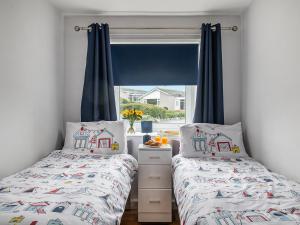 a bedroom with two beds and a window at Harbour View in Cemaes Bay