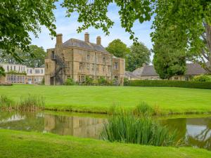 an old house with a pond in front of it at Hooke Court in Hooke