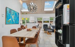 エーベルトフトにあるStunning Home In Ebeltoft With Kitchenのキッチン、ダイニングルーム(木製のテーブルと椅子付)