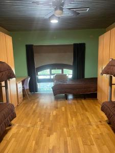 a living room with two beds and a large window at Albergue & Cafetería Vía de la Plata Hervás in Hervás