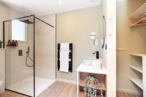 a bathroom with a shower with a glass door at La Villa face au Lac in Saramon