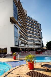 un hôtel avec une piscine en face d'un bâtiment dans l'établissement Hotel Nacional Inn Campinas Trevo, à Campinas