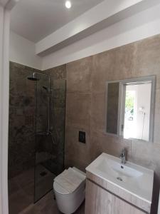 y baño con lavabo, ducha y aseo. en EvelMar Apartments - Dagli Apartment, en La Canea