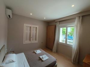 1 dormitorio con cama y ventana en EvelMar Apartments - Dagli Apartment, en La Canea