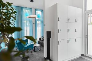 una sala de estar con armarios blancos y una silla azul en SERVENTO Boardinghouse, en Erlangen