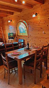 een houten eetkamer met een tafel en stoelen bij Villa Dandelion in Žabljak