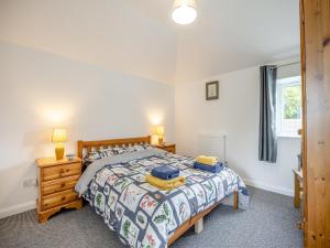 a bedroom with a bed and a dresser and a window at The Coach House in New Bolingbroke