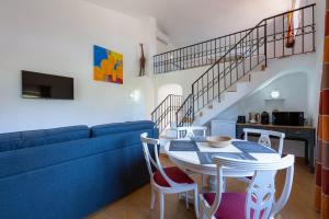 ein Wohnzimmer mit einem blauen Sofa, einem Tisch und Stühlen in der Unterkunft SOLAR DO MONTE 1 in Albufeira