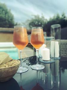 Très joli appartement équipé au calme في Rozay-en-Brie: كأسين من النبيذ يجلسون على رأس طاولة مع وعاء