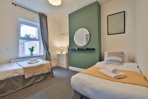 a bedroom with two beds and a mirror at Bradely st in Cardiff