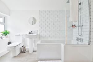 a white bathroom with a tub and a sink at Bradely st in Cardiff