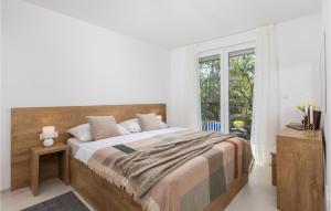a bedroom with a large bed and a window at Pet Friendly Home In Kraljevica in Kraljevica