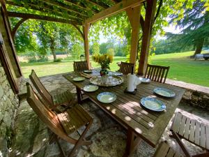 a wooden table with plates of food on a patio at Manoir du Suquet in Bardou