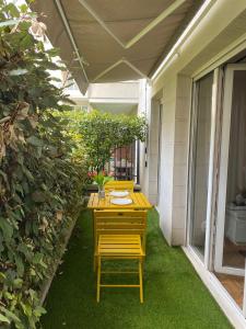 einen Tisch und Stühle auf einer Terrasse mit grünen Pflanzen in der Unterkunft F2 Paris 10ème Gare du nord - Stade de France - Parking in Saint-Denis