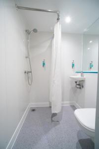 La salle de bains est pourvue d'une douche, de toilettes et d'un lavabo. dans l'établissement CiTi Hotel London Luton, à Luton