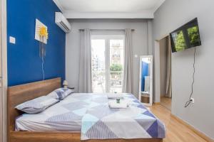 een slaapkamer met een groot bed met een blauwe muur bij Closer "Egnatia Apartment 2" in Thessaloniki