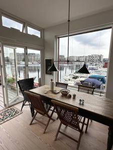 una sala da pranzo con tavolo, sedie e una grande finestra di Unique boathouse. a Copenaghen