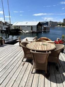a wooden deck with a table and chairs on a marina at Unique boathouse. in Copenhagen