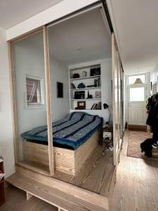 a bedroom with a bed in a room with a mirror at Unique boathouse. in Copenhagen