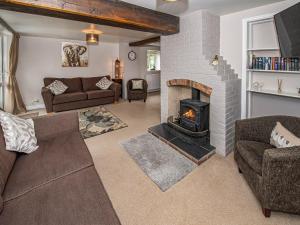 a living room with a fireplace and a couch at The Weaning Shed in Huggate
