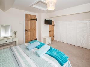 a bedroom with a bed with blue pillows on it at The Weaning Shed in Huggate