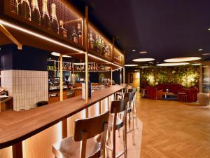 a bar in a restaurant with chairs and tables at ibis Styles Nantes Reze Aéroport in Rezé